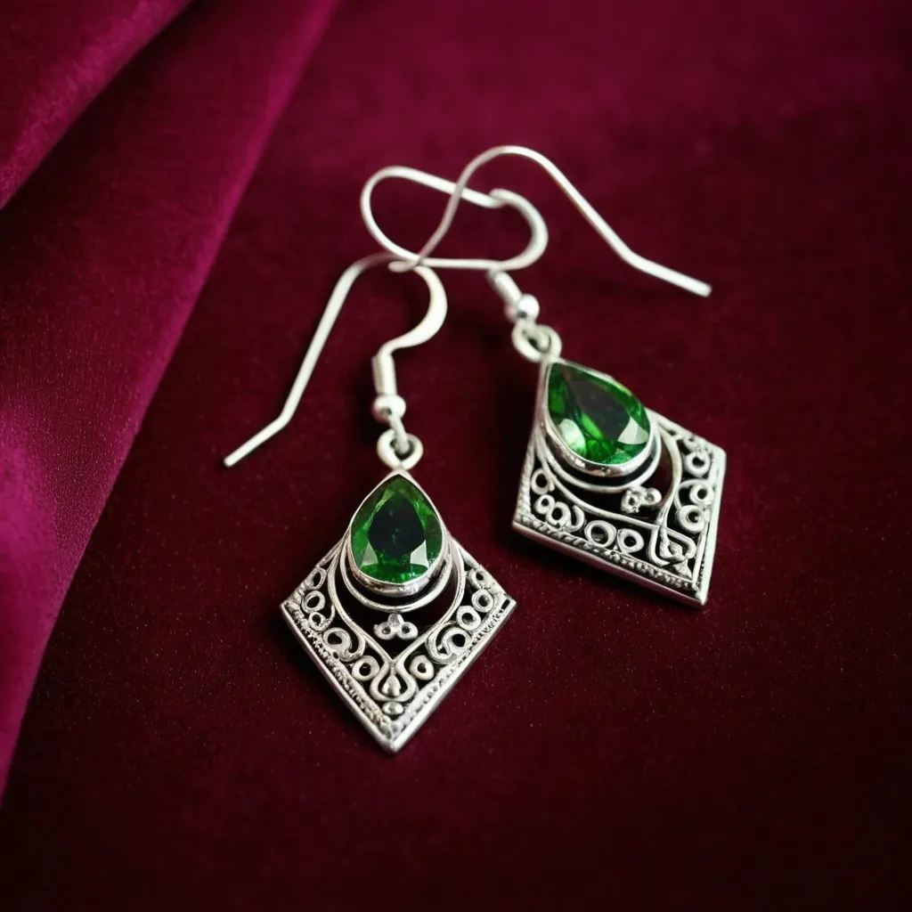 detailed photo of silver earrings with green gem